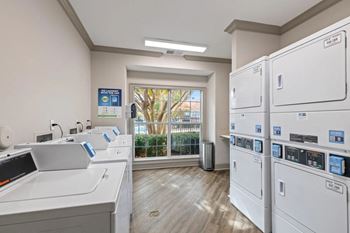 Laundry room with washers and dryers and a window
